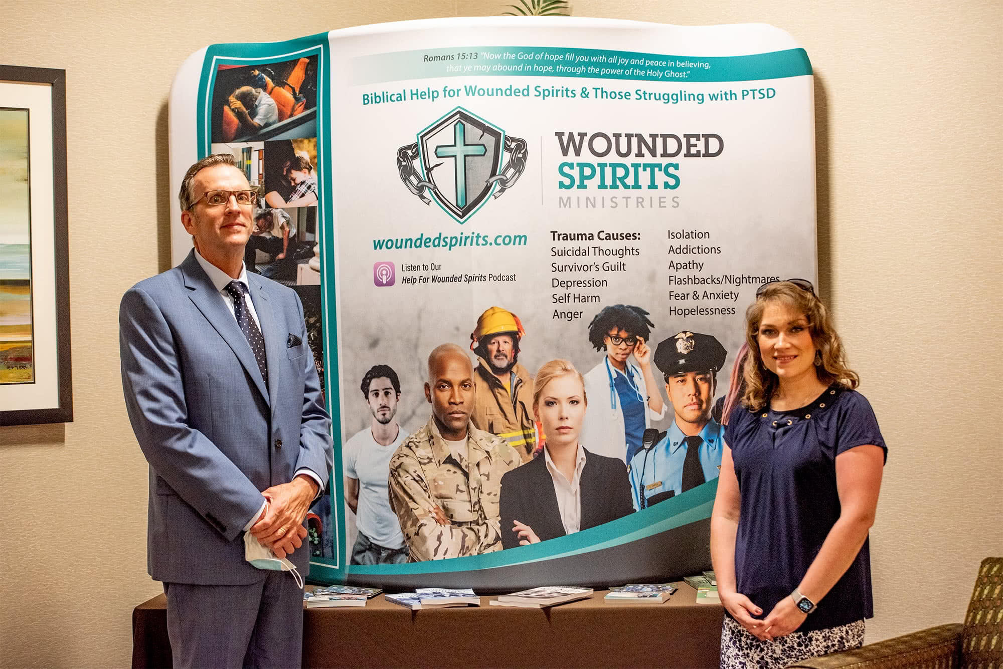 Wounded Spirits Ministries table with the Director and his wife standing in front of it