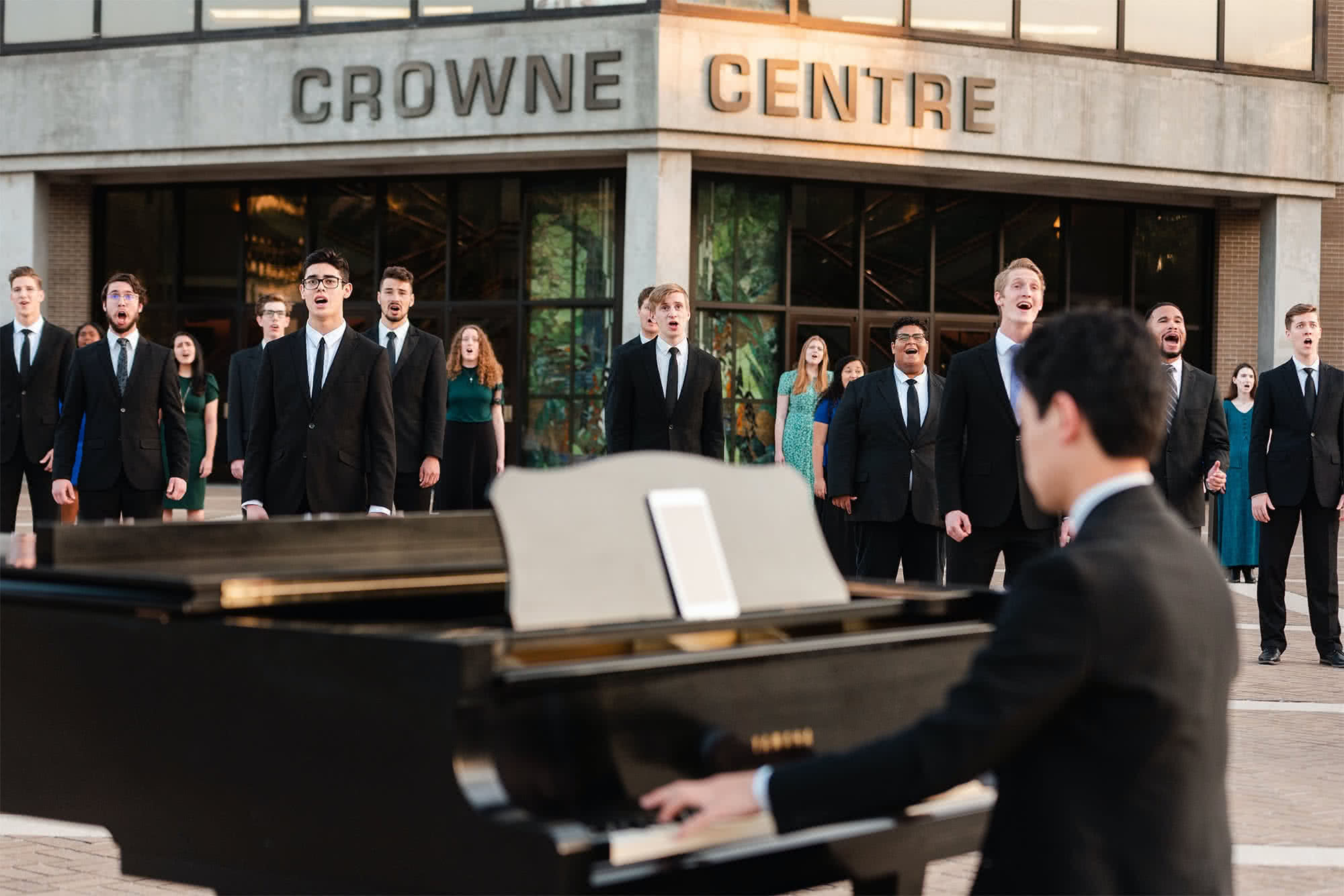 Choir and piano in front of Crowne Centre