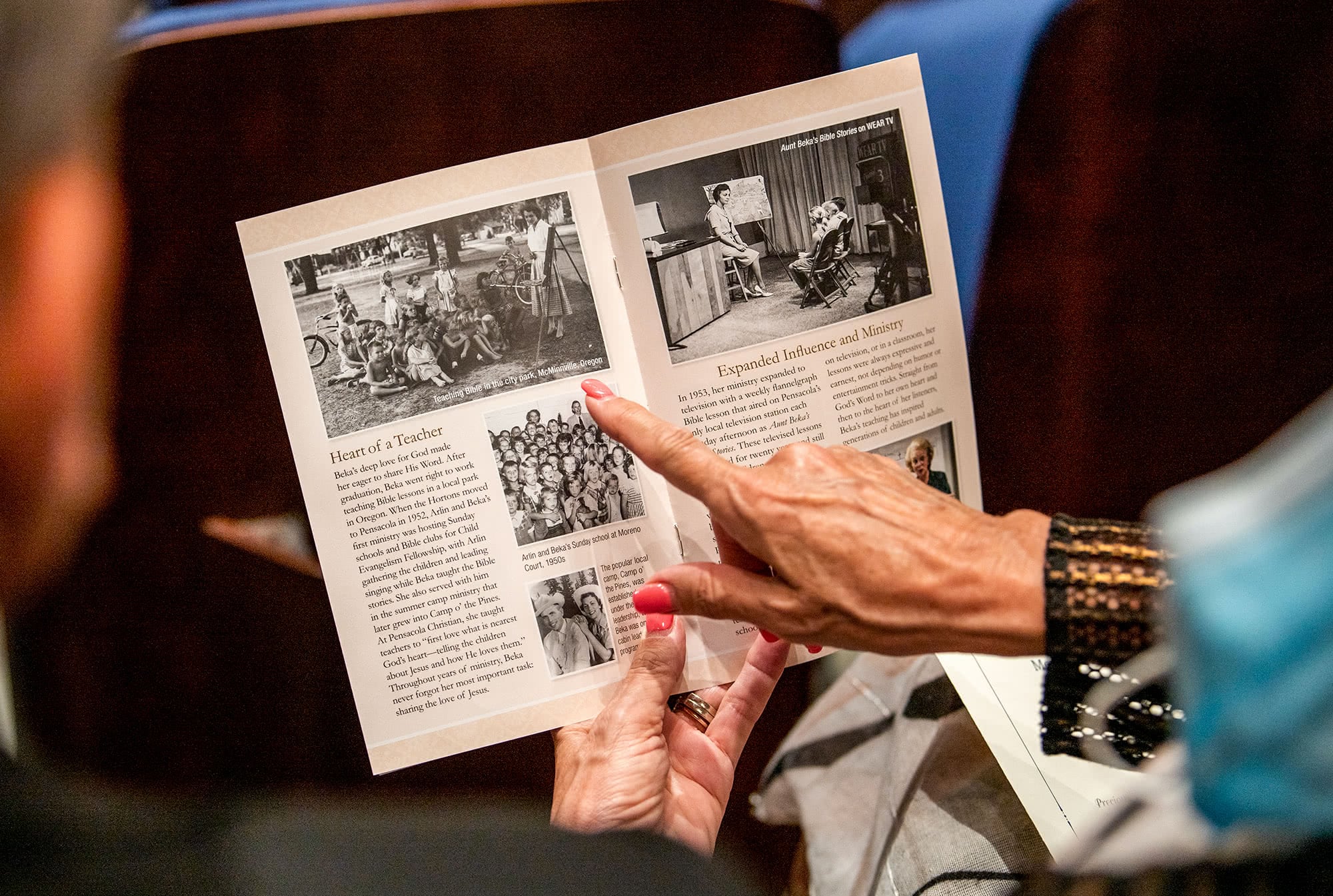 Guest pointing out photo in funeral brochure.