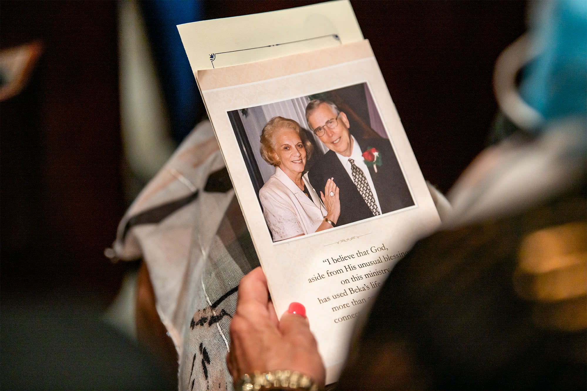Close up of a guest holding the funeral program. 