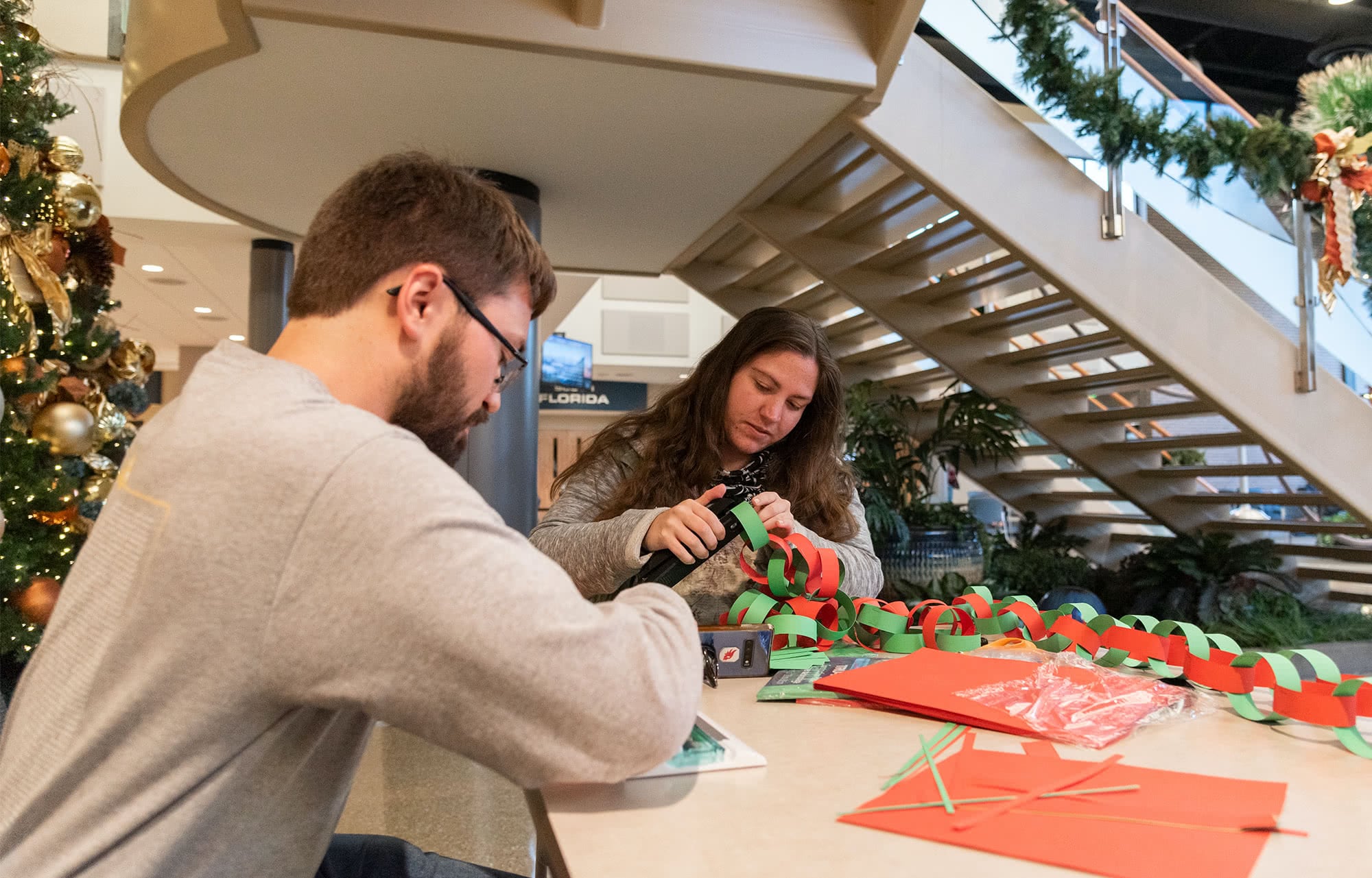 Male and Female students make a Christmas paper chain