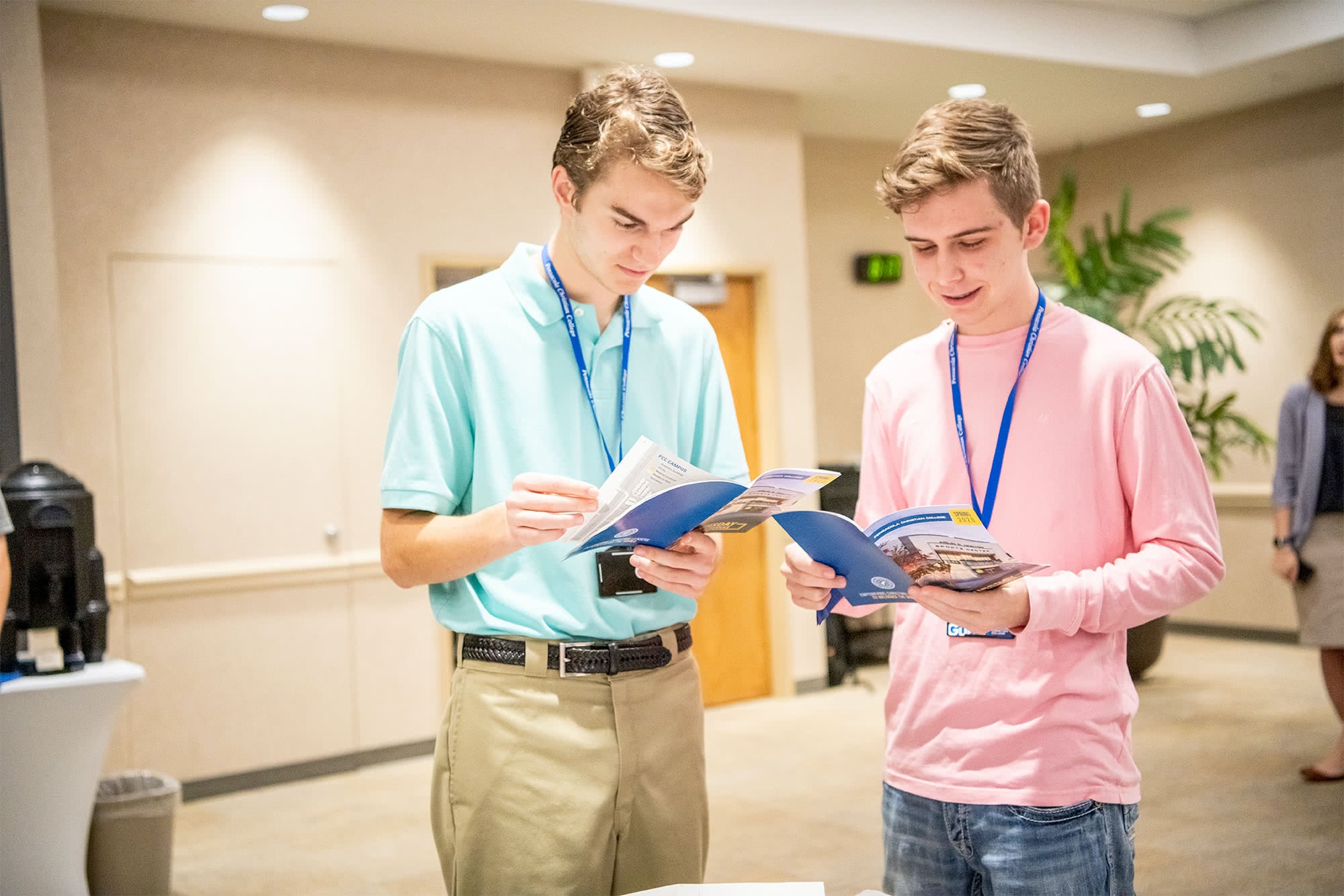 Two male students looking at College Getaway booklets. 