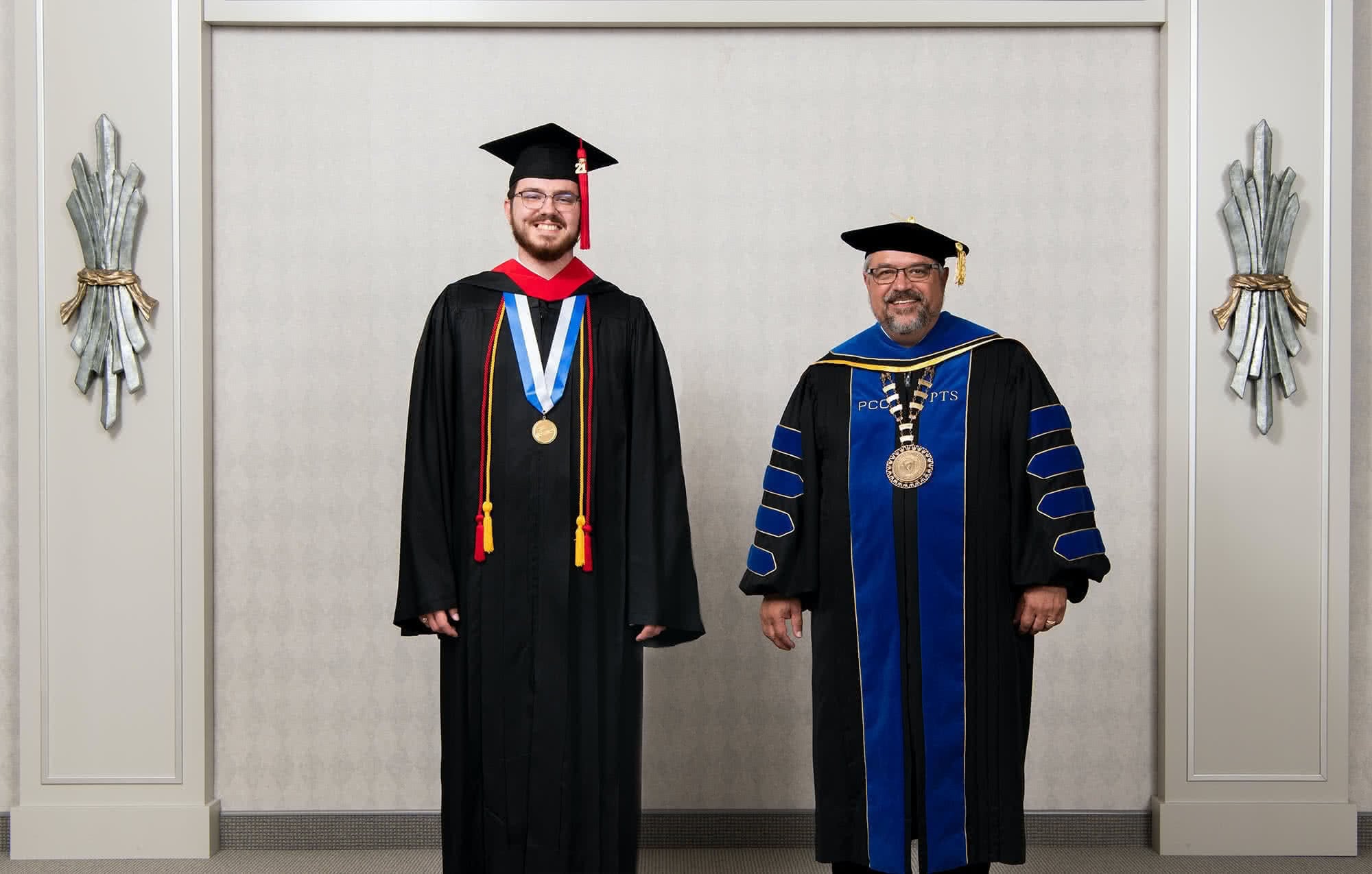Male graduate poses with Dr. Shoemaker