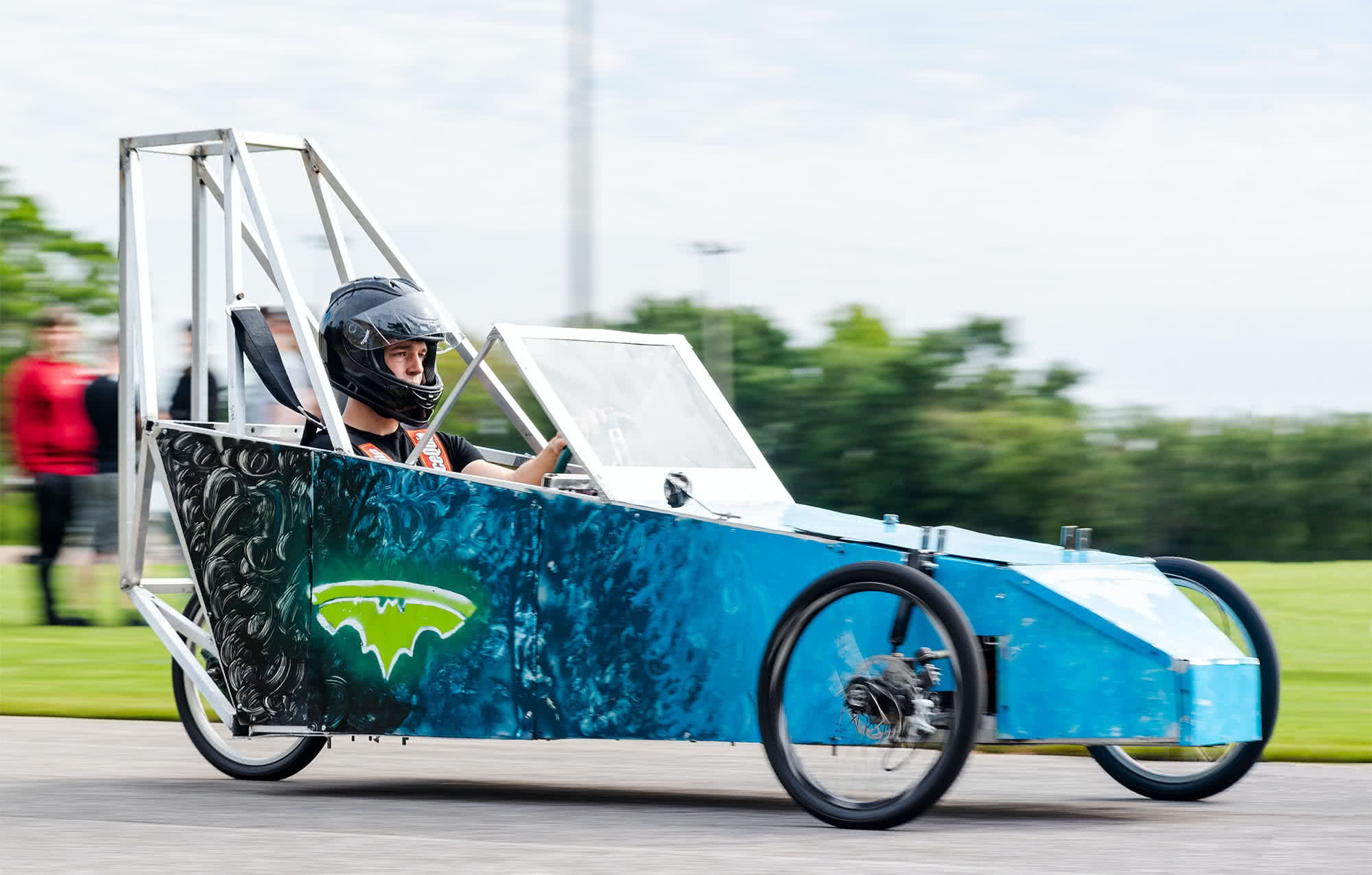 Student racing in a blue electric vehicle. 
