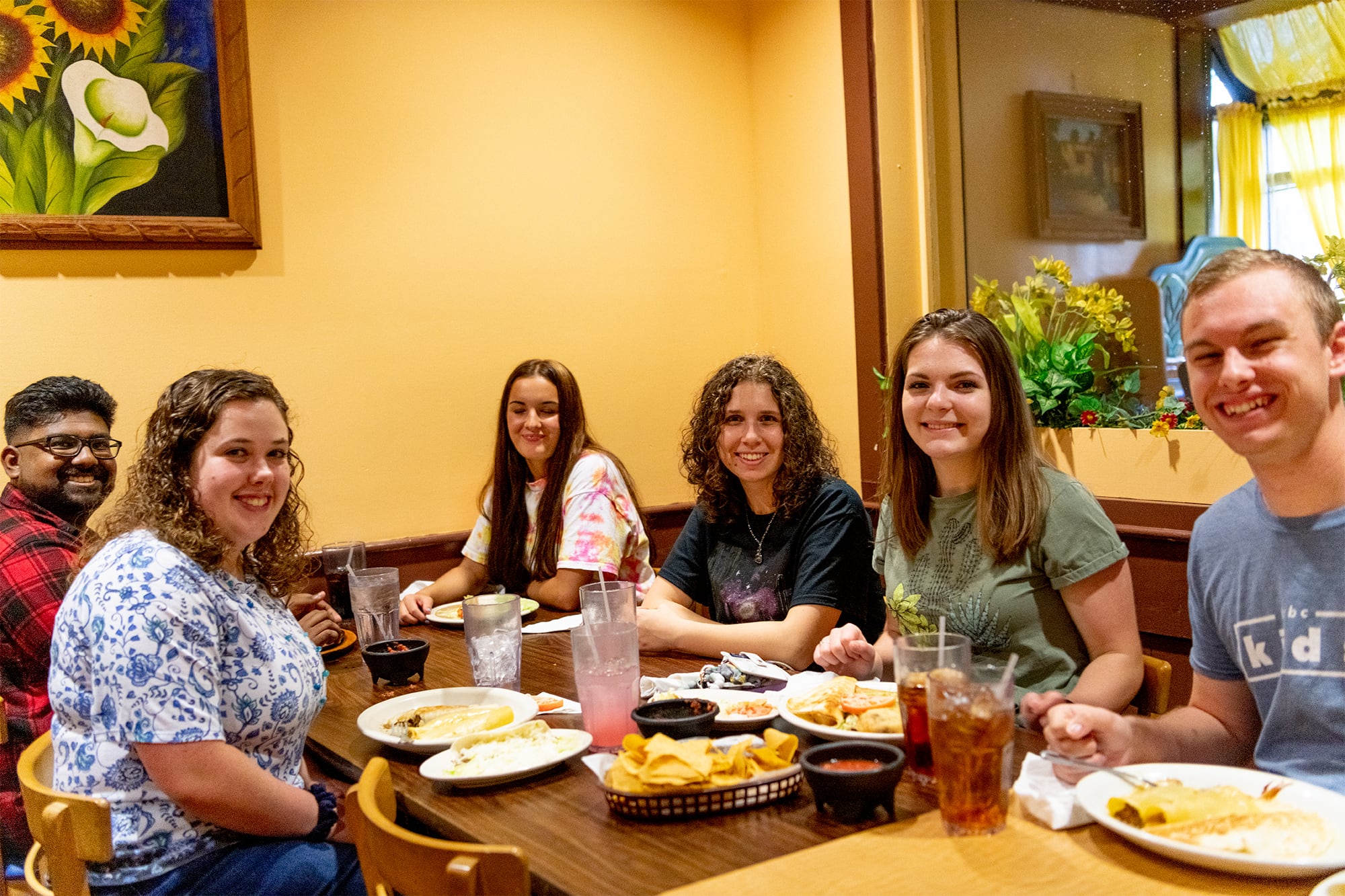 Summer student workers sitting at a restaurant table for a student outing. 