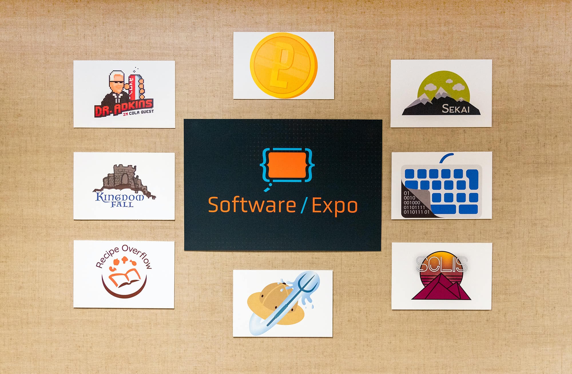 Photos on a desk of the Software Expo logo and student's logo designs. 
