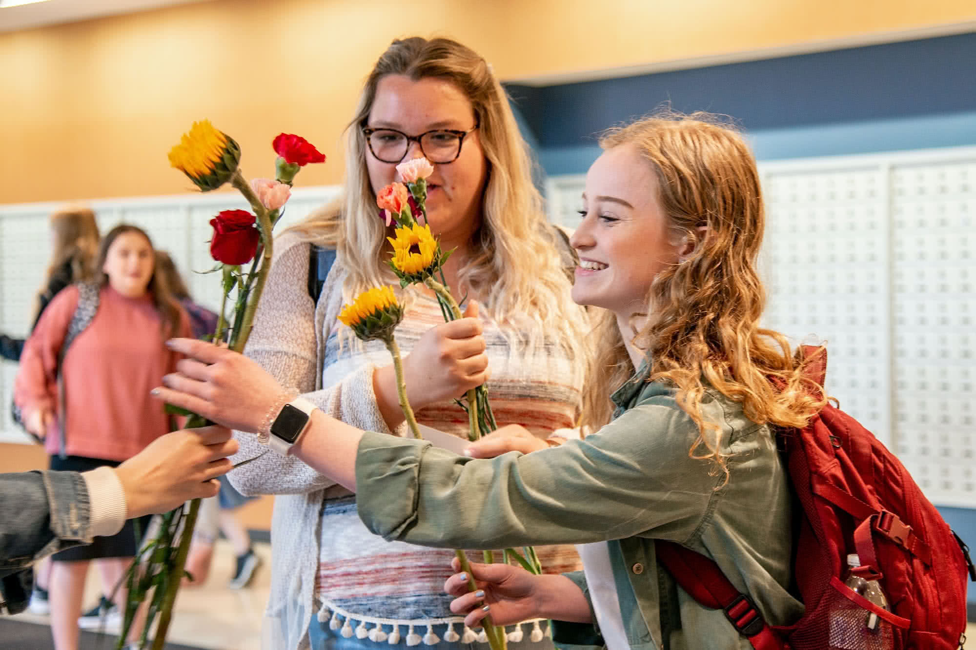 Two female students receiving flowers in the PCC Commons.