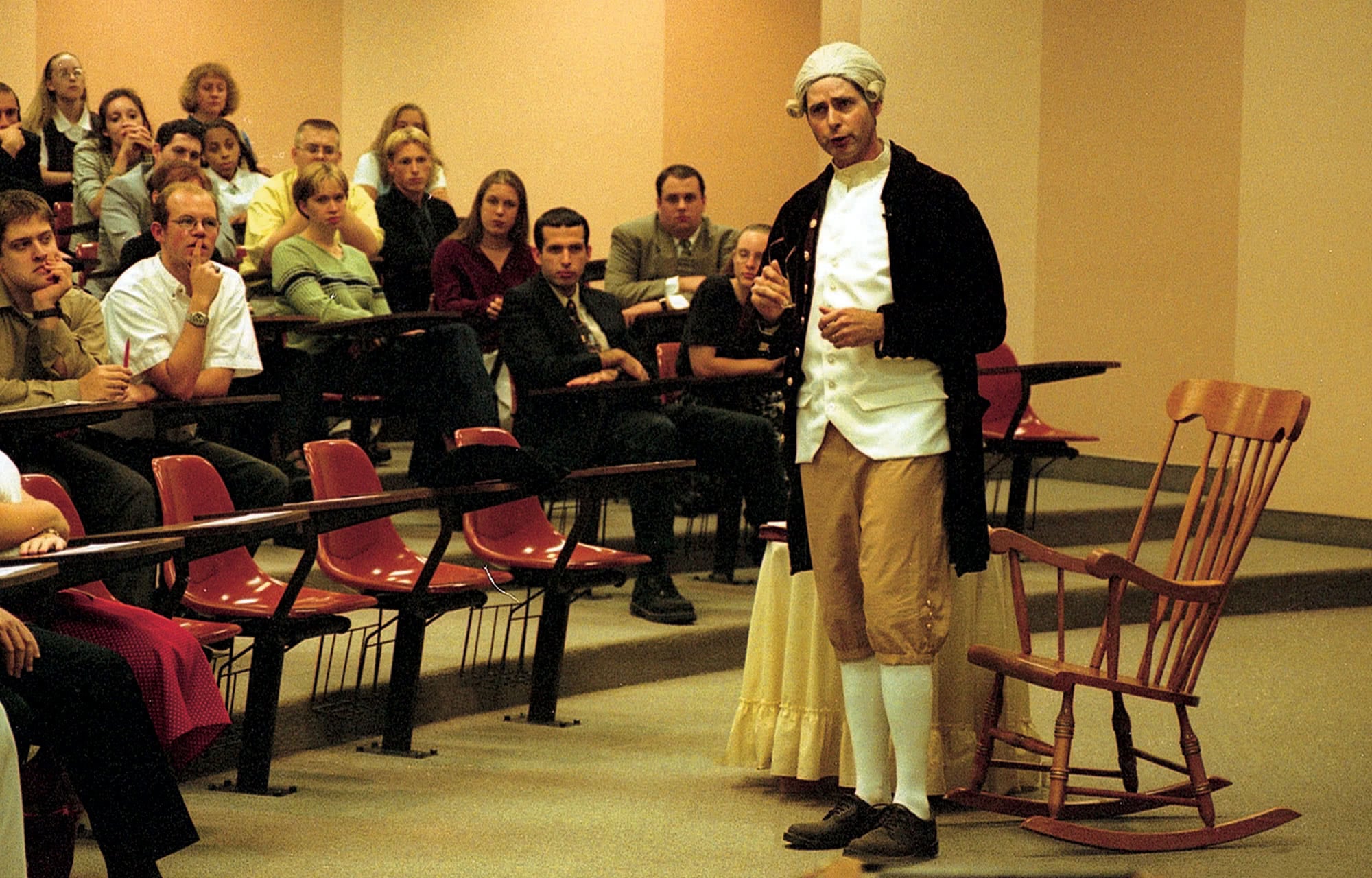 John Reese dressed as a founding father teaches a seminar in the Lyceum