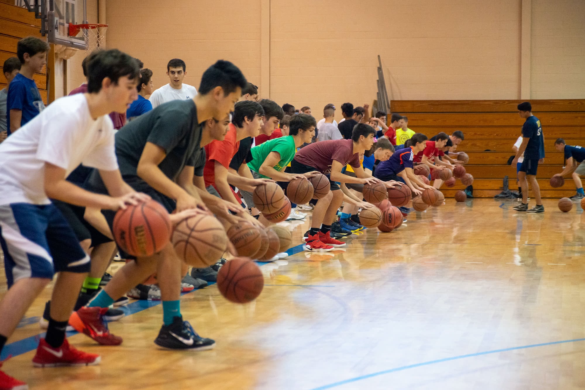 Boys lined up dribbling basketballs in the PCC Field House.