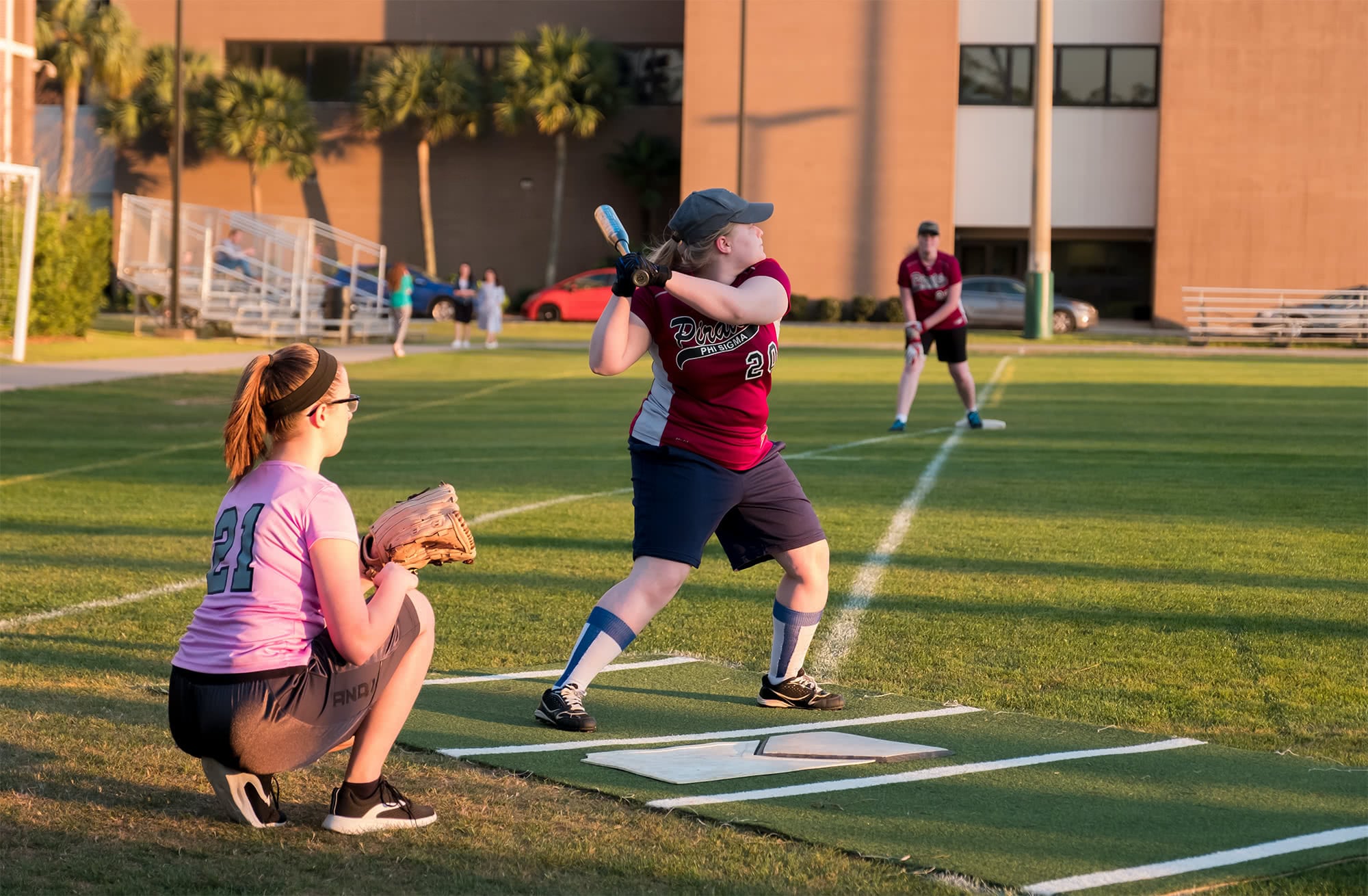 Women's collegian softball player aiming to swing the bat. 