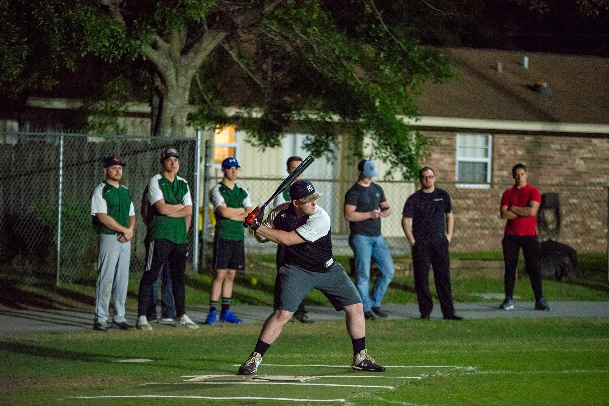 Men's collegian softball player preparing to swing a bat. 