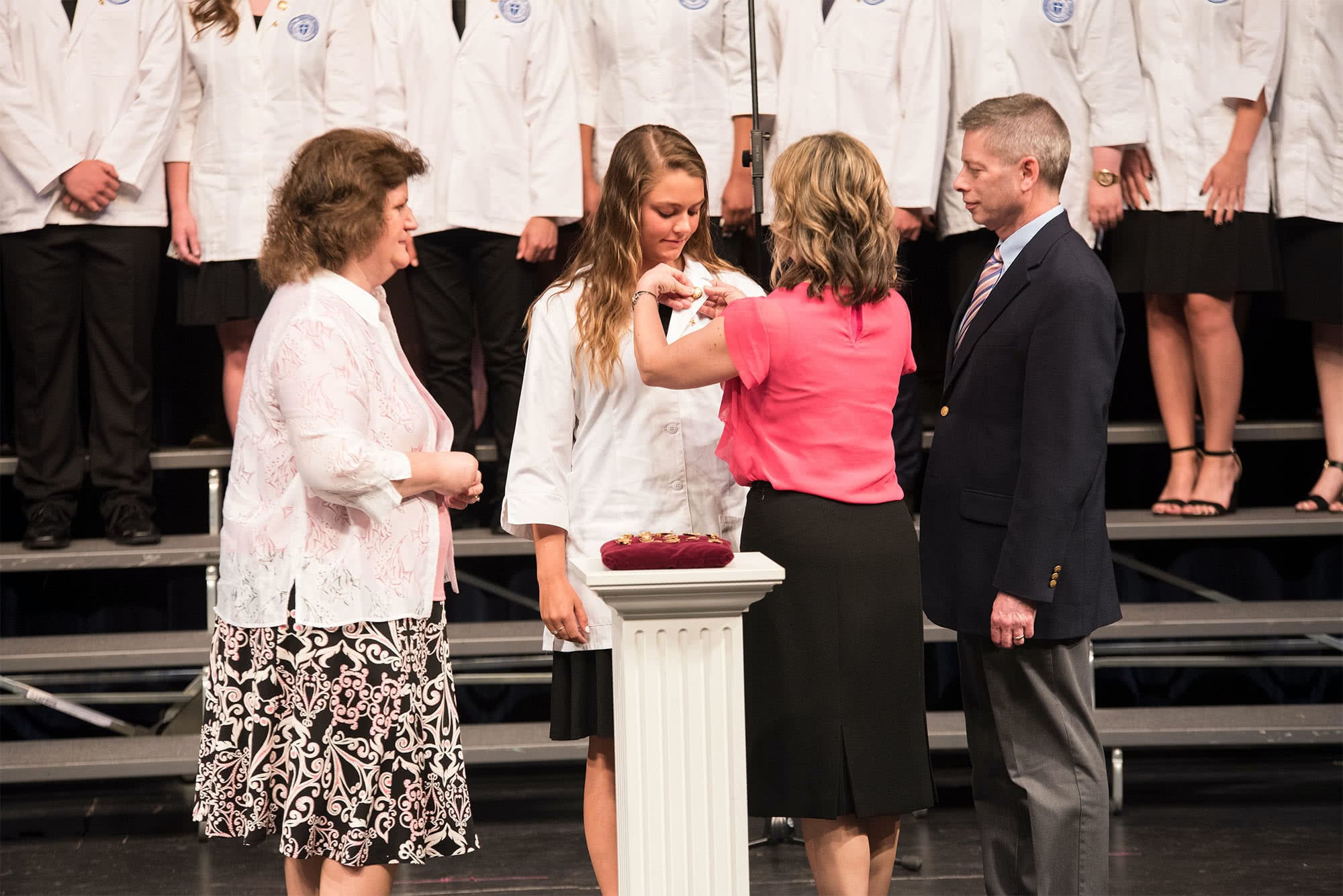 Parents pin their daughter at the Nurses' Pinning Ceremony
