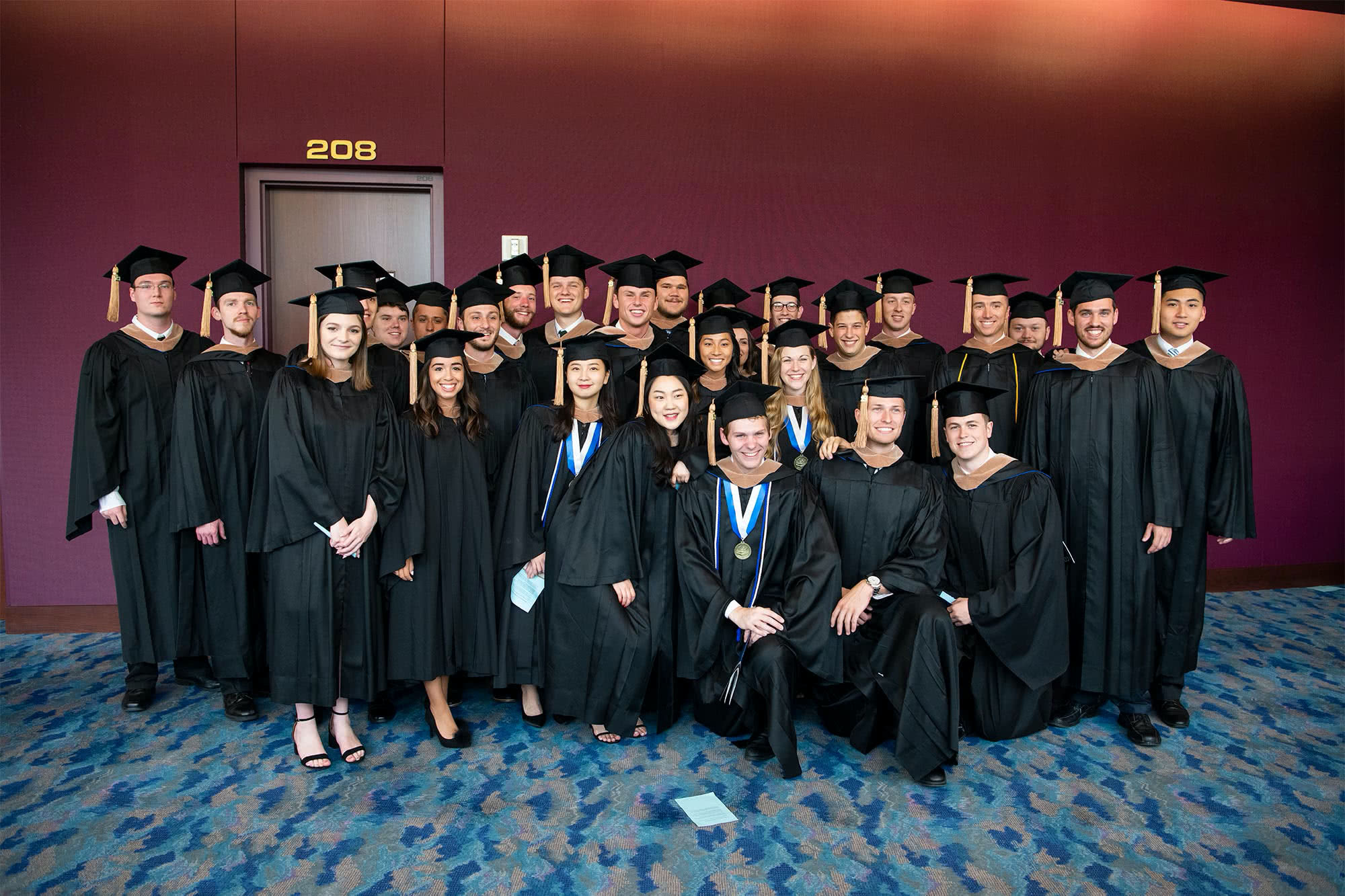 A group of business graduates pose together before graduation starts
