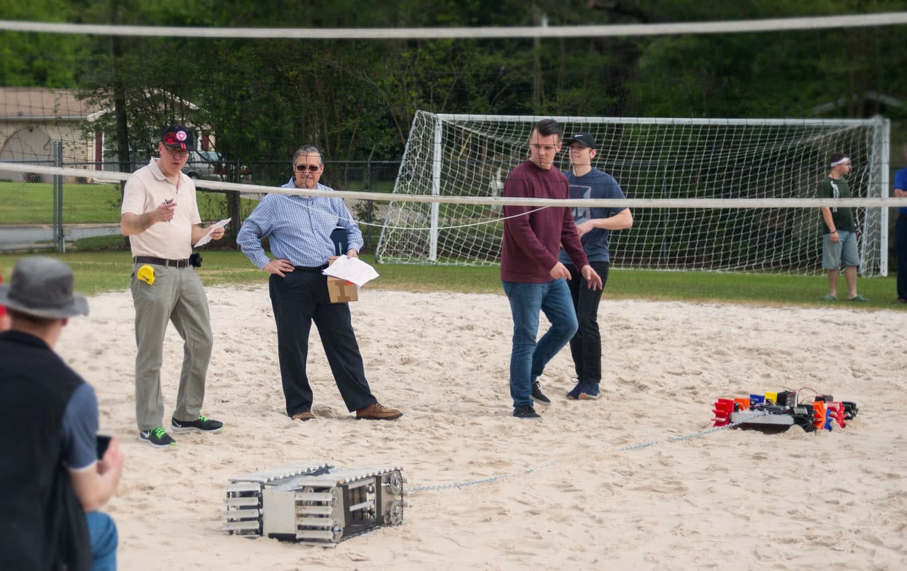 Engineering students by volleyball court preparing for contest