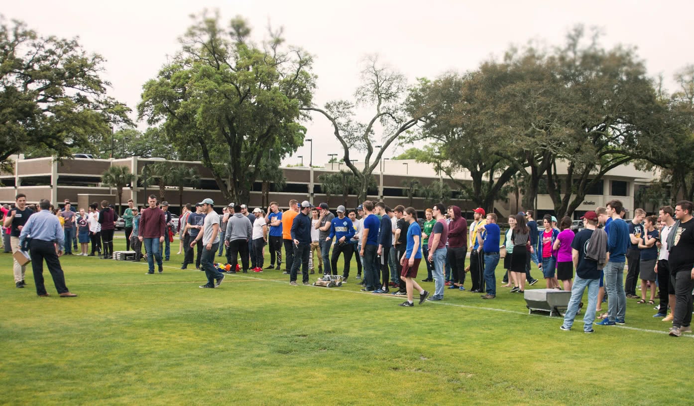 Engineering students gathered on the field as teams line up their robots to race.