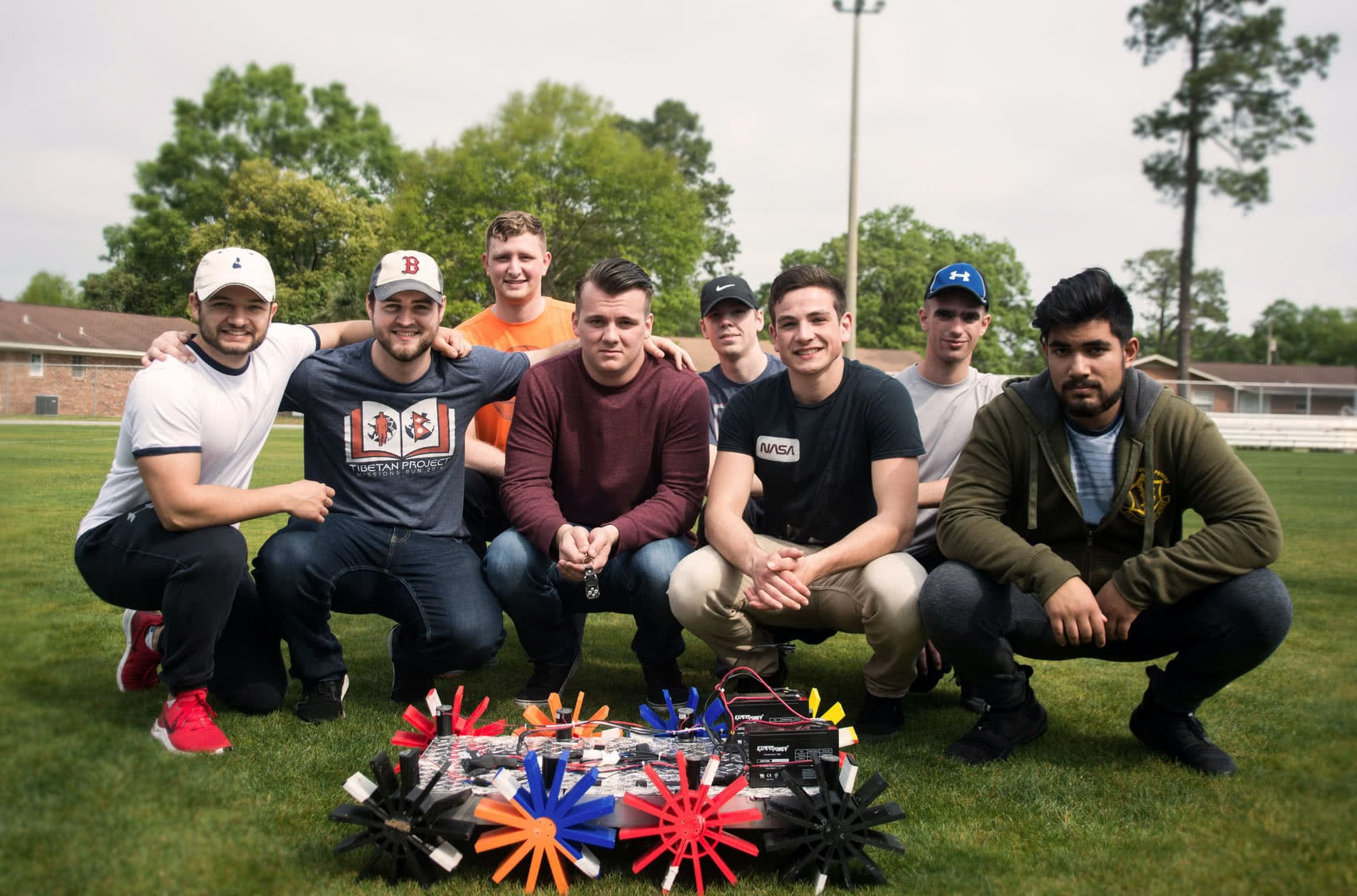 Engineering students pose with their vehicle robots.