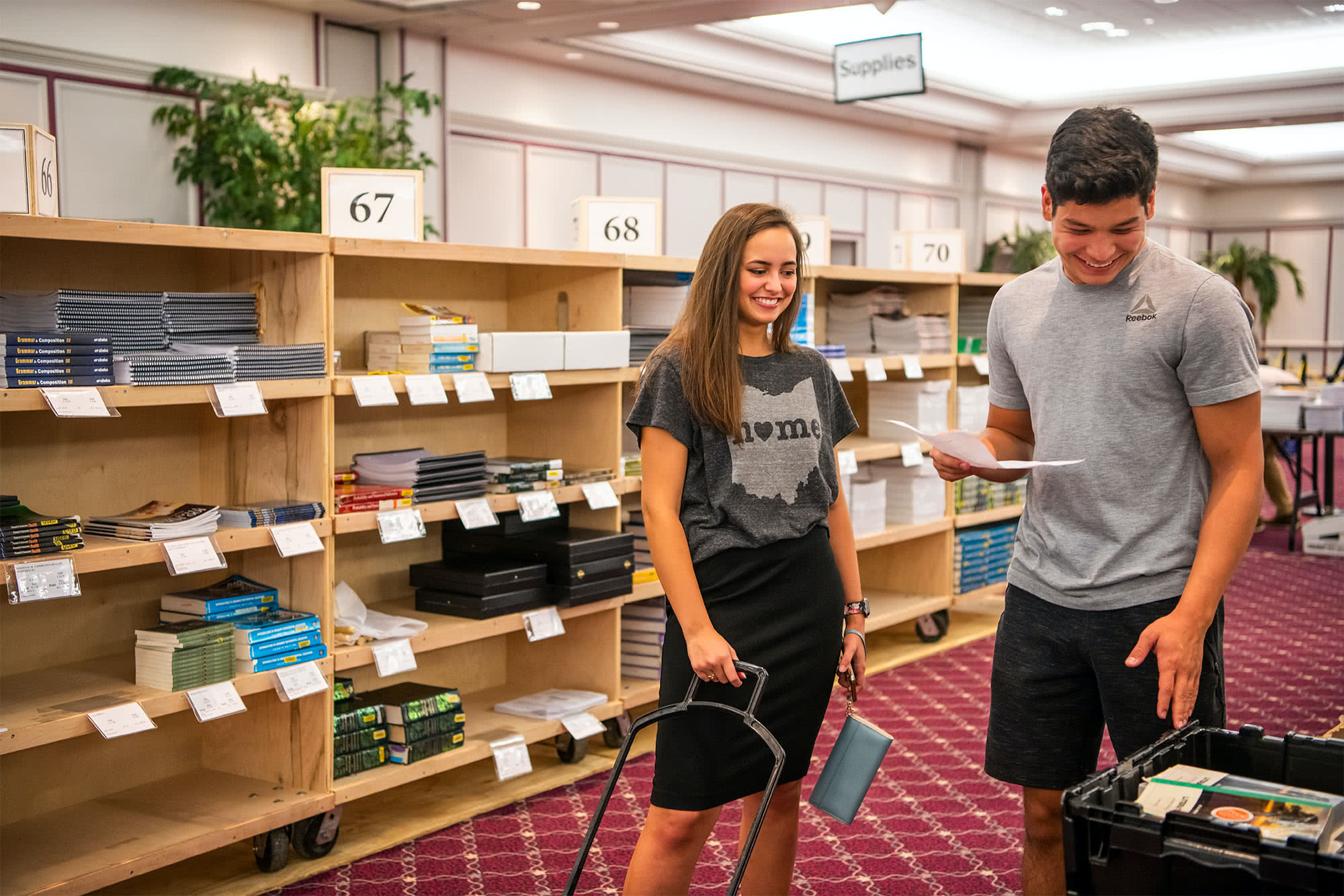 Two students find their books at the textbook sale