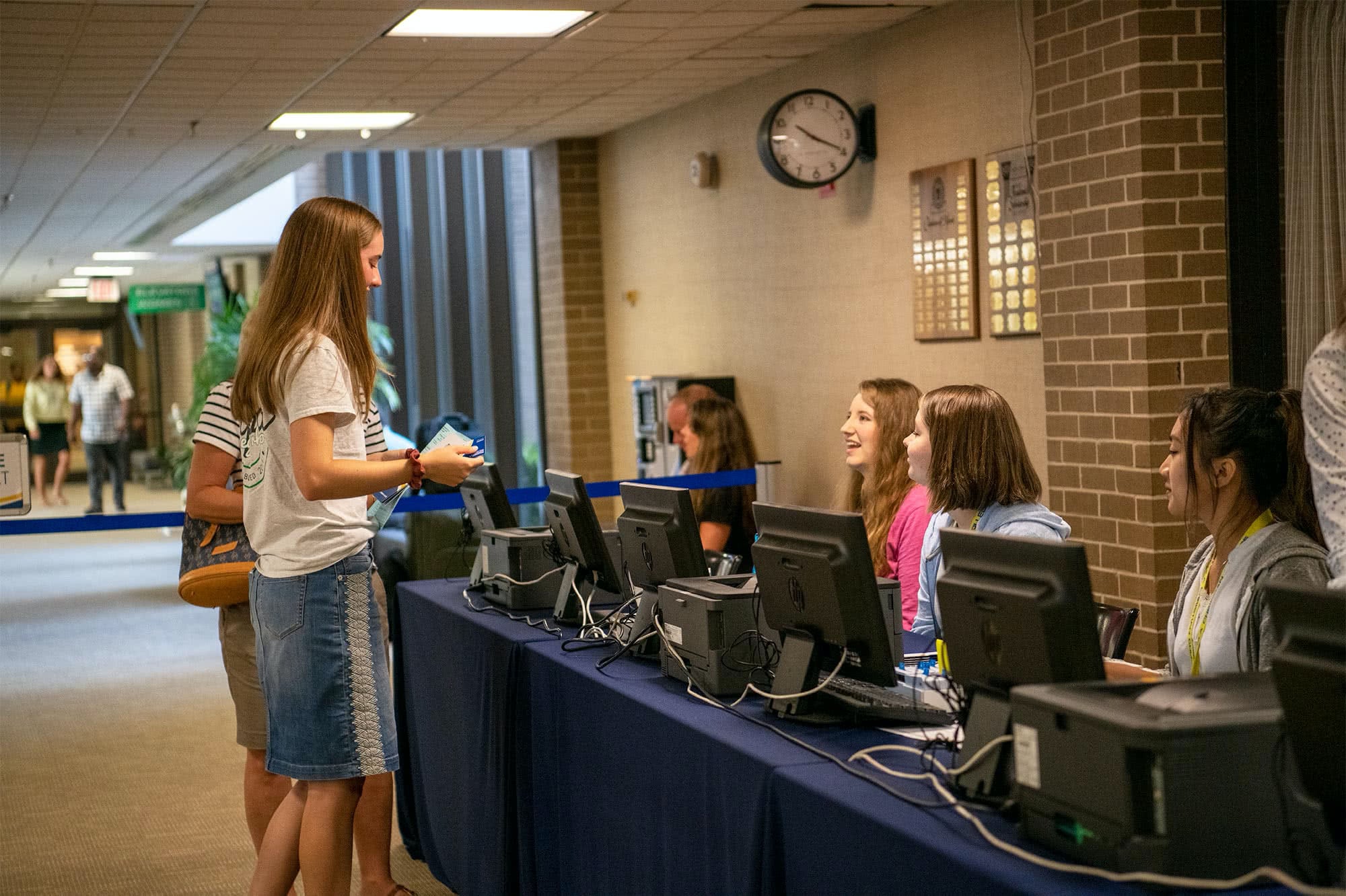 A female student checks in and receives her ID card