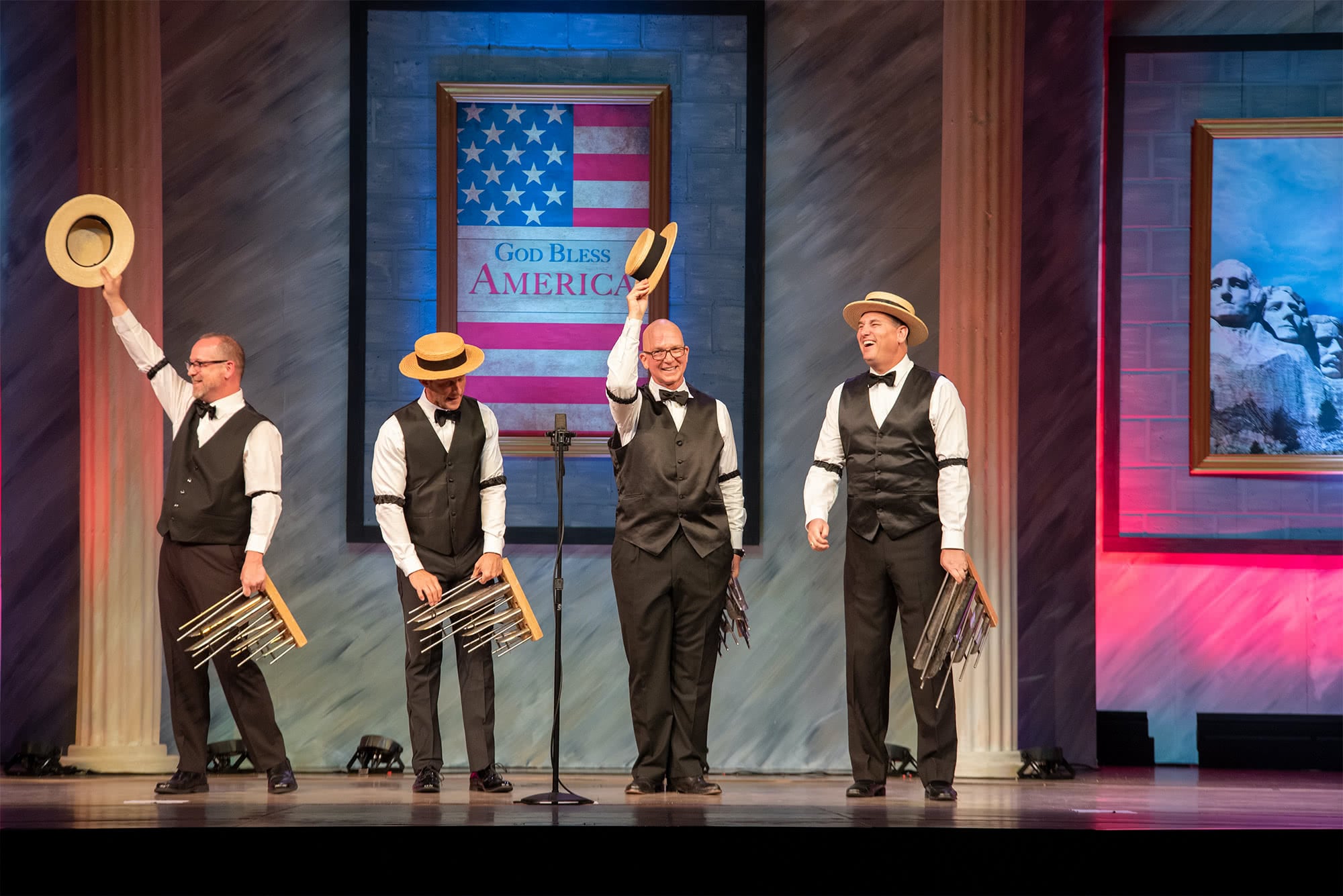 The Humdingers barbershop quartet wearing hats and vests and playing organ chimes.