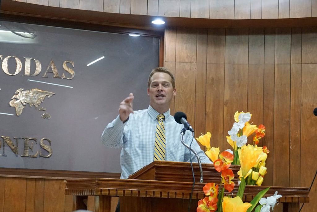 Matt Goins standing at a pulpit and preaching. 