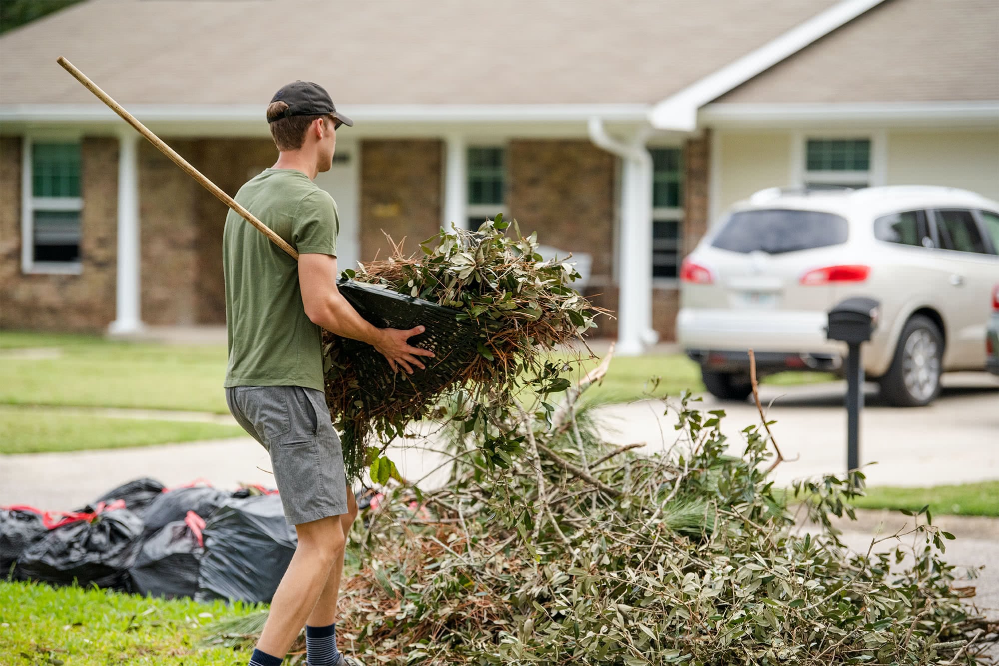 A male student cleans up debris in a nearby neighborhood