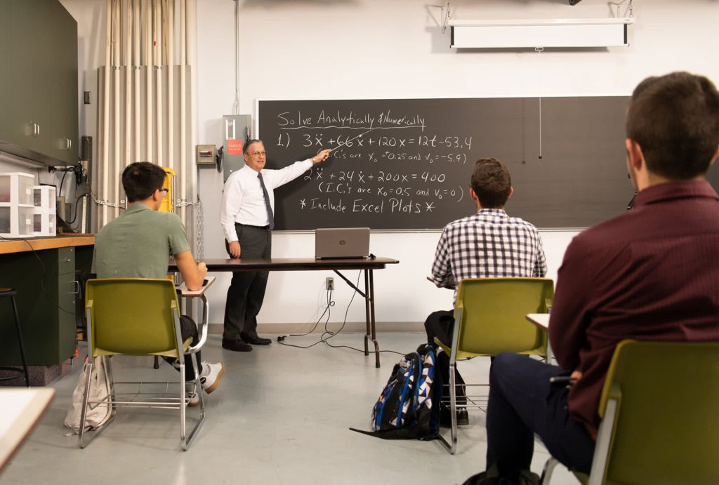 Dr. Joel Porcher teaching at chalkboard.