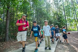 Jordan Weise walking with campers at Camp o' the Pines. 