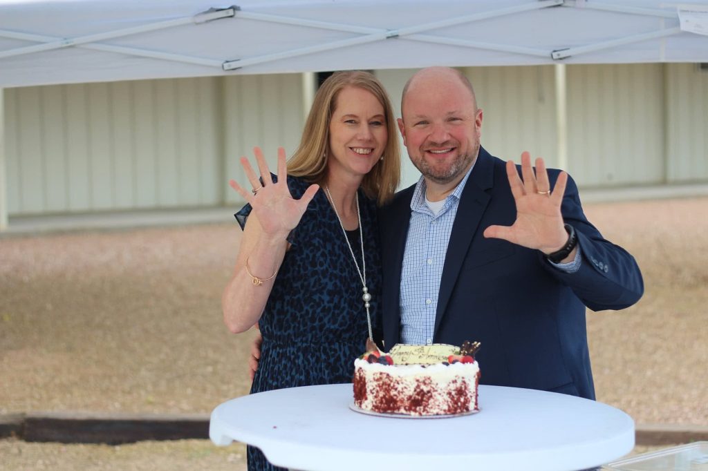 Pastor Ray McCormick and his wife standing with cake. 