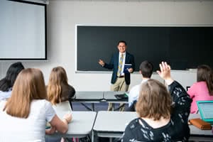 Teacher standing in the front of a classroom and teaching. 