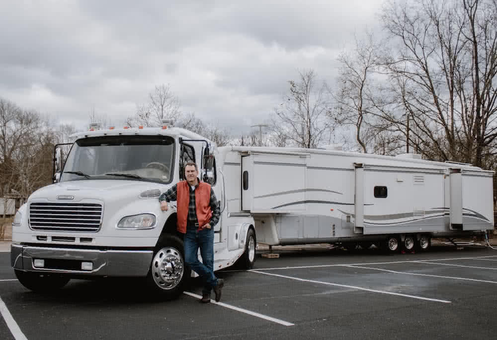 Rich Tozour standing in front of a camper. 
