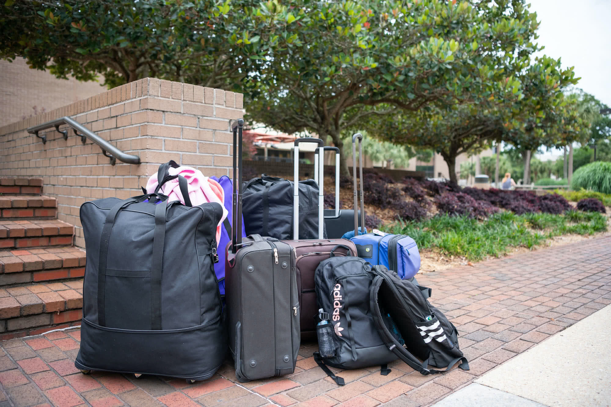 A pile of luggage sits on the sidewalk in front of the Commons waiting to be packed