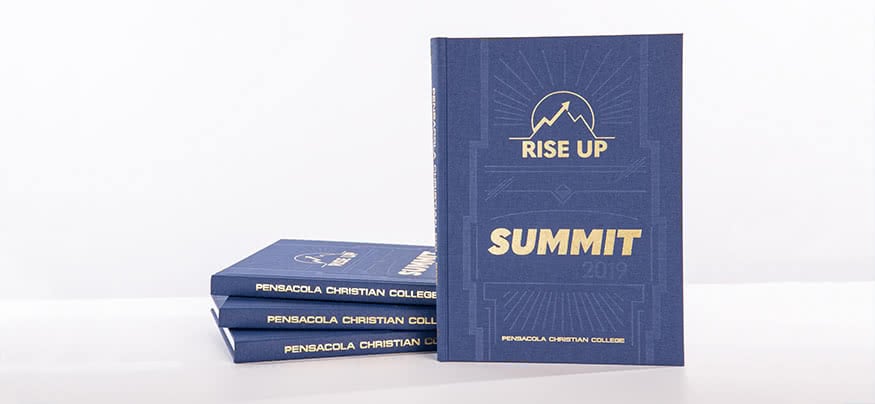 The 2019 yearbook is a blue with an indented pattern. The Student body theme logo for the year, Summit, and Pensacola Christian College are in gold.