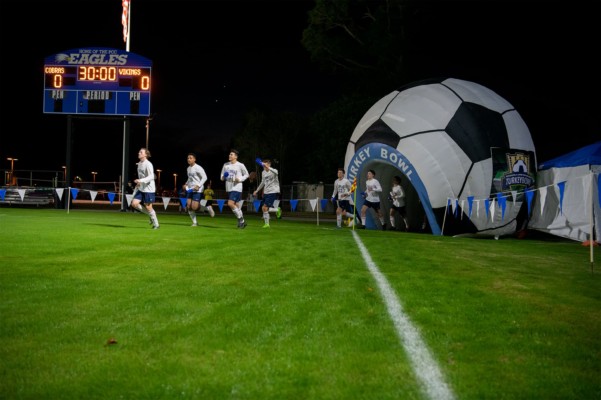 Cobra players run onto the field through the large inflatable soccer ball tunnel