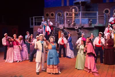 The cast of H.M.S. Pinafore sings on board the ship