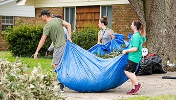 Students clean up debris in a nearby neighborhood