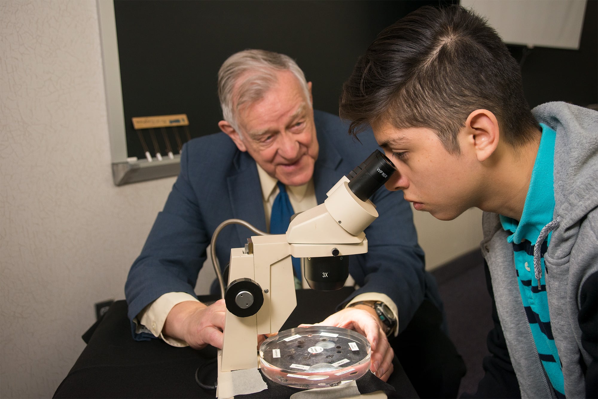 student looking in microscope.