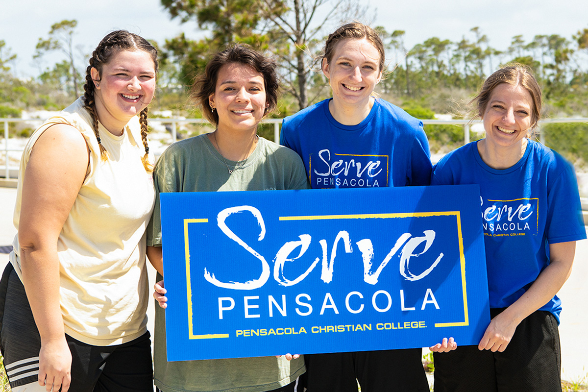 Girls holding Serve Pensacola sign