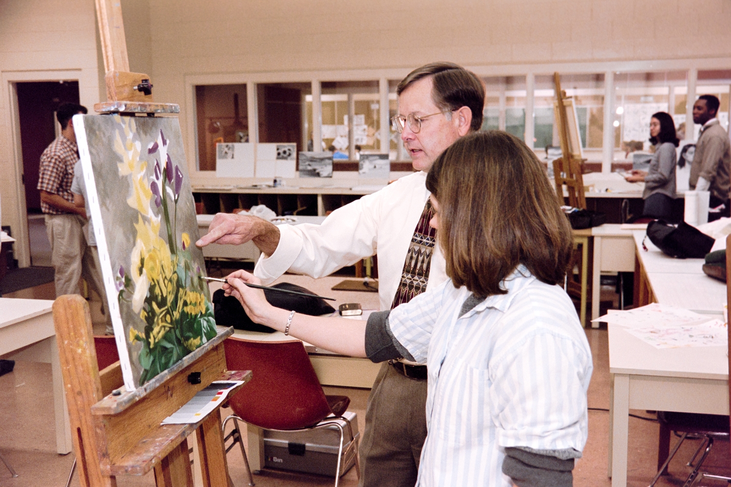 Stan Shimmin helping a student in an art class.