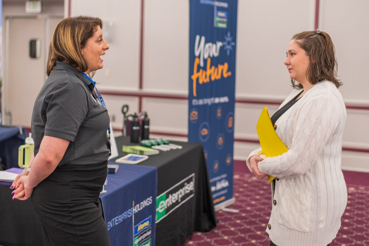 PCC girl speaks with an Enterprise representative at the 2023 Career Fair