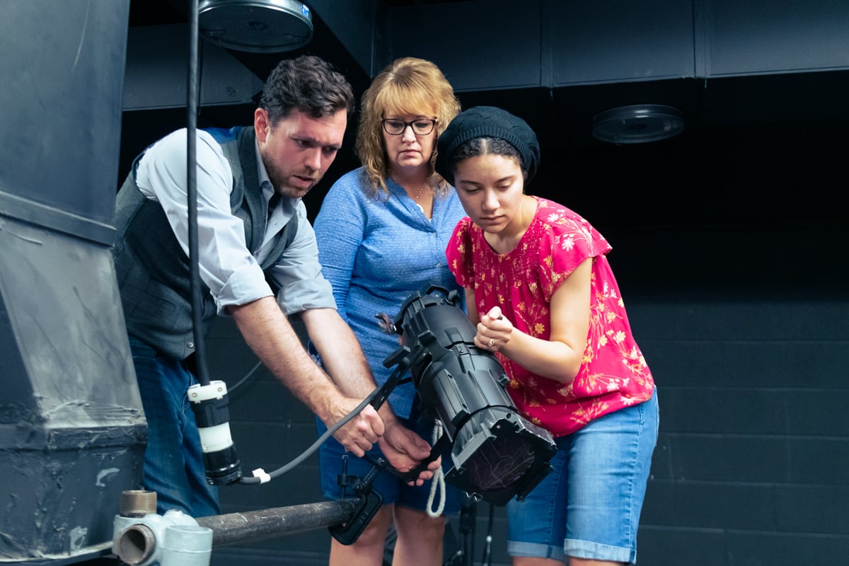 Graduate students behind the scenes of a Dramatic Production set